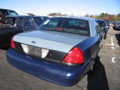 2001 Ford Crown Victoria - Rear view of a two-tone Ford Crown Victoria parked in a lot with other vehicles.