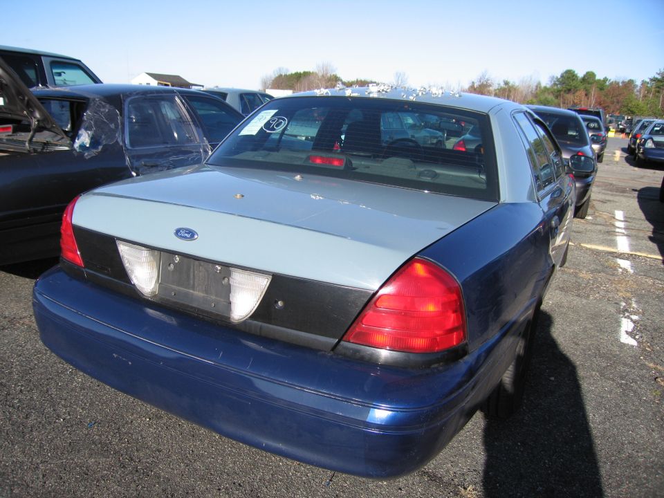Blue and silver Ford Crown Victoria, rear view, dented bumper, cracked rear window