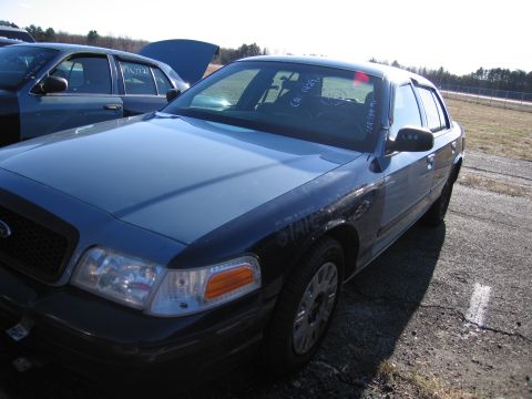 2001 Ford Crown Victoria - Front quarter view of a 2001 Ford Crown Victoria, with another similar vehicle behind it.