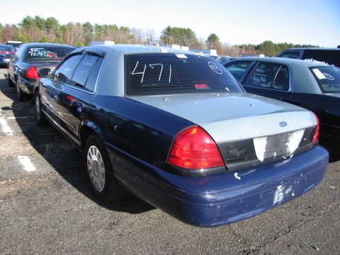 2001 Ford Crown Victoria - Rear view of a 2001 Ford Crown Victoria parked outdoors with other vehicles.