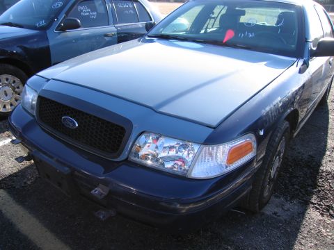 2001 Ford Crown Victoria - A blue Ford Crown Victoria is parked outdoors, with another vehicle partially visible to its left.