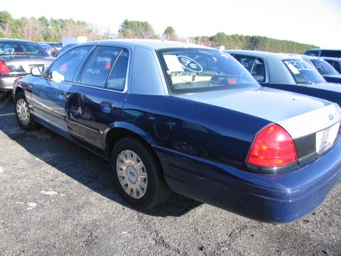 2001 Ford Crown Victoria - This 2001 Ford Crown Victoria, seen from a three-quarter front perspective, is a two-tone dark blue and light blue sedan with noticeable da…