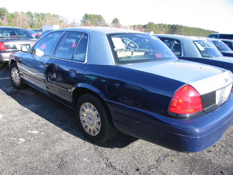 2001 Ford Crown Victoria, 3q-front view, dark blue and light blue two-tone sedan with dented driver's side door