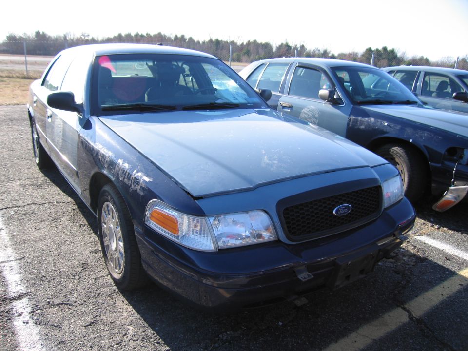 Blue police car, front 3/4 view, showing grille and headlights. Text on fender reads 'POLICE'