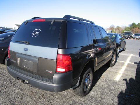 2001 Ford Crown Victoria - A Ford Explorer is parked in a lot, showing its rear end and part of its side profile.