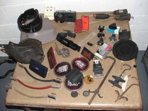 1989 Ford Bronco II - Various automotive parts are laid out on a table, including lenses, switches, and a speaker.