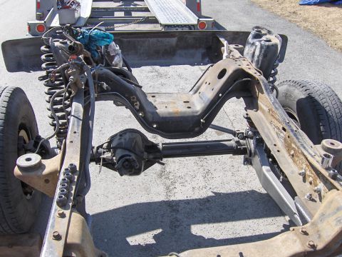 1990 Ford Bronco - The chassis and suspension components of a vehicle are visible, mounted on a trailer.