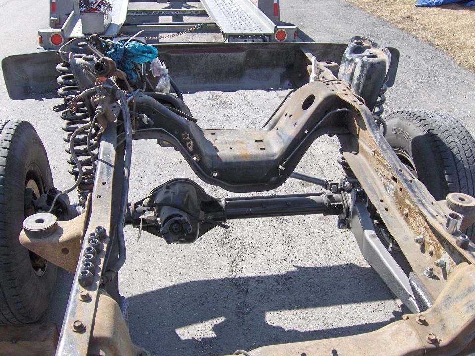 Vehicle frame with front axle and suspension parts, on a trailer