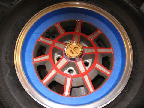 1968 Shelby GT500 - A wheel with a Shelby Cobra emblem is partially covered in blue tape, suggesting preparation for painting.