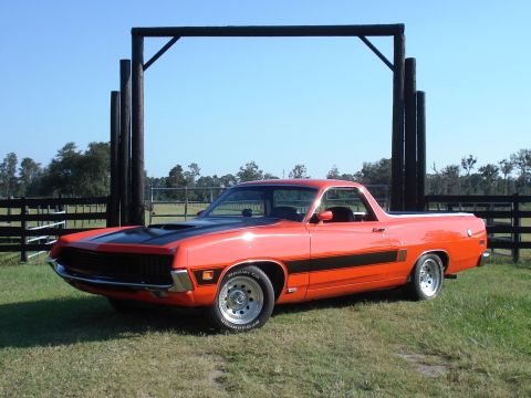 1970 Ford Ranchero - This 1970 Ford Ranchero is parked on a grassy area with a wooden structure in the background.