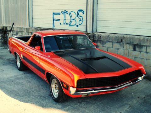 1970 Ford Ranchero - This 1970 Ford Ranchero features a bold red paint job with black accents on the hood and sides.