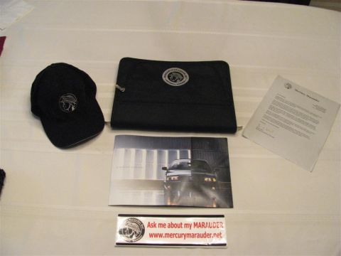 2003 Mercury Marauder - Promotional items for a Mercury Marauder, including a cap, brochure, and documentation, are laid out on a surface.