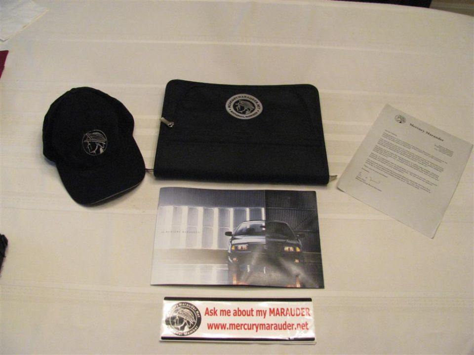 Mercury Marauder club hat, portfolio, brochure, letter and bumper sticker on table