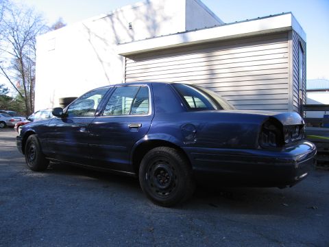 1991 Ford LTD Crown Victoria - Dark blue 1991 Ford Crown Victoria LTD parked outside a building, missing rear body panels.