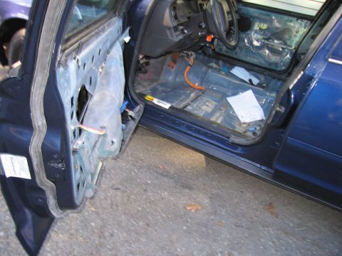 1991 Ford LTD Crown Victoria - Interior view of a blue car with its doors removed, revealing exposed wiring and the bare floor.