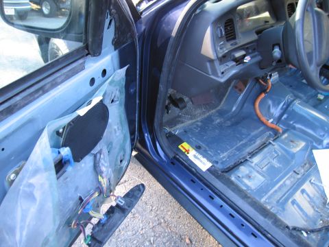 1991 Ford LTD Crown Victoria - The interior of a blue 1991 Ford Crown Victoria LTD shows exposed wiring and a stripped-down cabin.