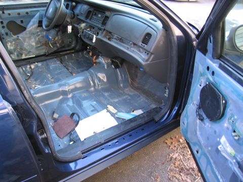 1991 Ford LTD Crown Victoria - The interior of a 1991 Ford Crown Victoria LTD shows a stripped-down cabin with exposed metal and removed door panels.