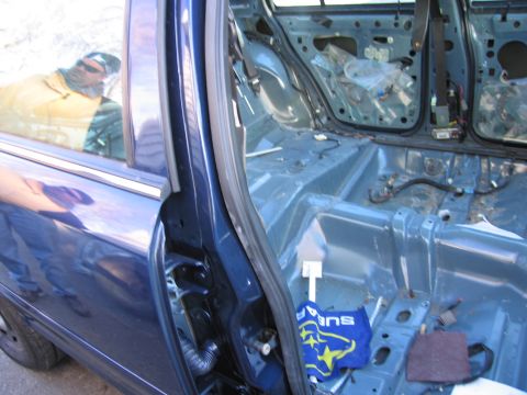 1991 Ford LTD Crown Victoria - Interior of a blue car stripped down for work, revealing the bare metal chassis and wiring.