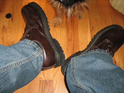 1988 Mercury Grand Marquis - A close-up view of brown leather boots and blue jeans worn by a person, with a dog visible in the background.