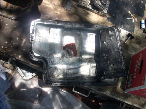 1992 Ford Bronco - Transmission pan and filter removed for service, revealing internal parts and a red rag inside the pan.