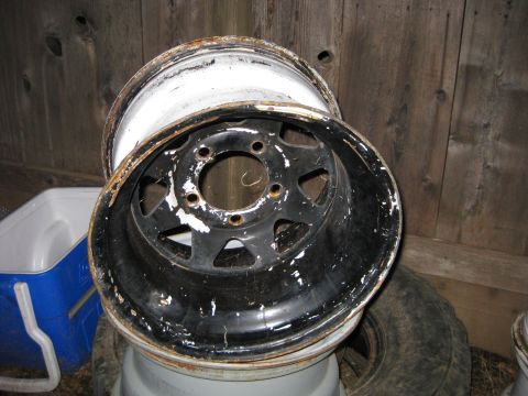 1995 Ford Bronco - A single, used steel wheel rim shows significant wear and paint damage.