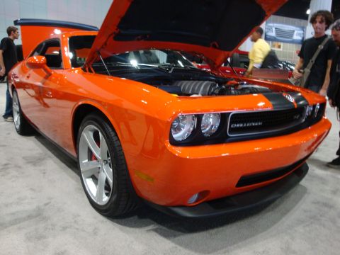 1993 Ford Taurus - An orange Dodge Challenger is displayed with its hood open, revealing the engine and a prominent grille badge.