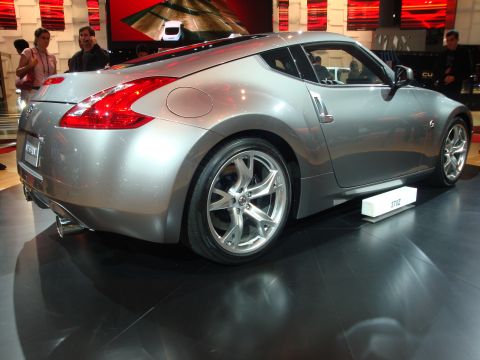 1993 Ford Taurus - Silver Nissan 370Z displayed at an auto show.