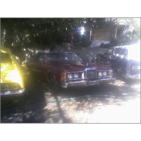 1973 Mercury Cougar - Front view of a 1973 Mercury Cougar parked outdoors with other vehicles nearby.