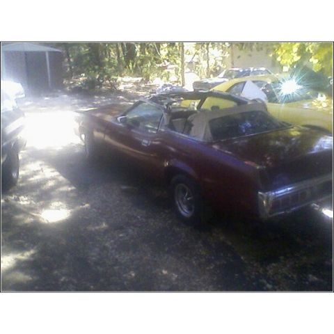 1973 Mercury Cougar - A maroon convertible is parked in a driveway with another car visible in the background.