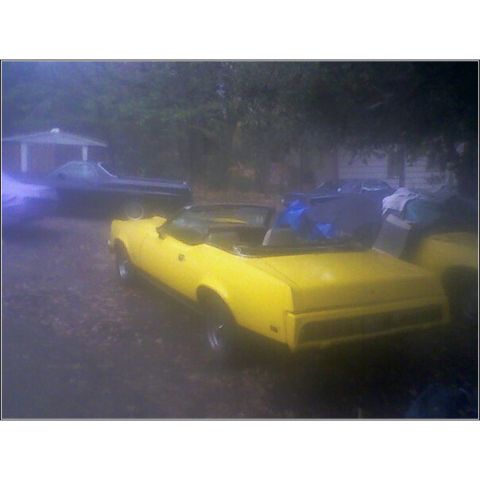 1973 Mercury Cougar - Yellow 1973 Mercury Cougar convertible with a dark-colored car behind it.