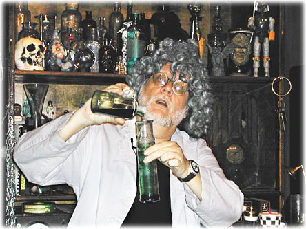 1991 Ford Crown Victoria - A man dressed as a mad scientist mixes liquids in bottles, surrounded by a collection of strange items.