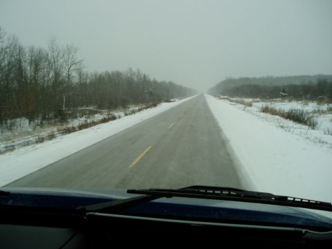 1995 Mercury Grand Marquis - Driving through a winter landscape with snow lining the road and trees.