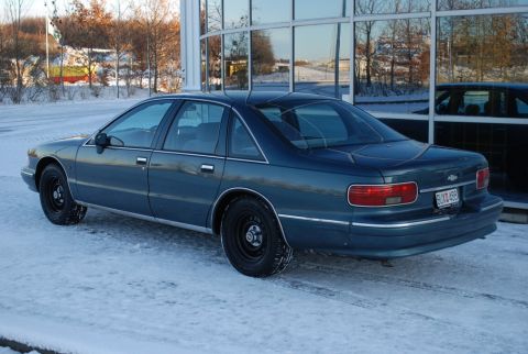 1998 Ford Crown Victoria - This Chevrolet Caprice sedan is seen from the rear-three-quarter angle on a snowy day.
