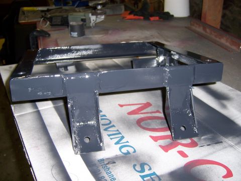 1991 Ford Bronco - A metal seat bracket is shown from a close-up angle, resting on a cardboard box.