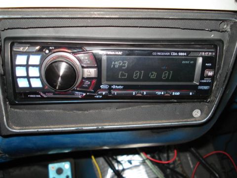 1979 Chevrolet C/K Pickup - Close-up of an aftermarket car stereo with digital display and control buttons.