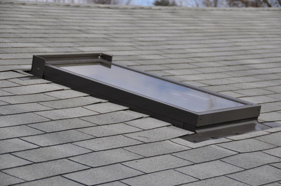 skylight installed on a gray asphalt shingle roof