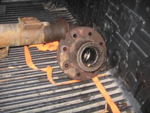 1988 Ford Bronco - Close-up of a Dana 70 rear axle part, likely a housing and hub, resting in a truck bed.