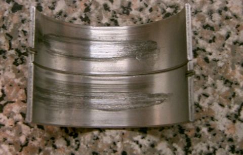 2007 Ford Mustang - This engine bearing shows significant wear and scoring, indicating potential internal engine damage.