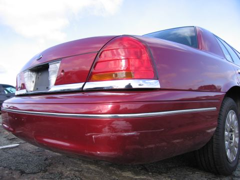 2001 Ford Crown Victoria - Rear view of a red 2001 Ford Crown Victoria showing the quarter panel and bumper.