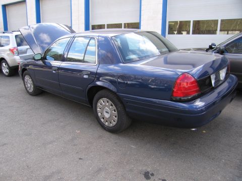 1991 Ford LTD Crown Victoria - Blue sedan parked outdoors with its hood open, next to a silver SUV.