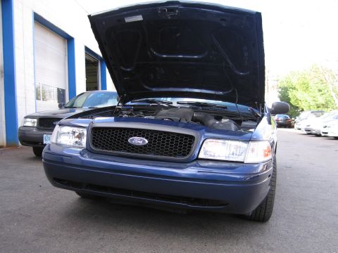 1991 Ford LTD Crown Victoria - A blue Ford Crown Victoria is parked with its hood open, and another similar car is behind it.