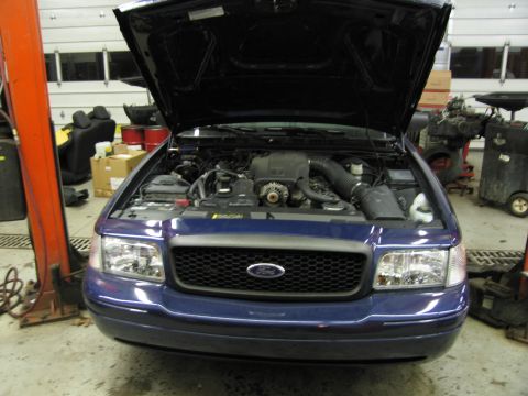 1991 Ford LTD Crown Victoria - Front view of a blue Ford Crown Victoria with its hood open, revealing the engine compartment.