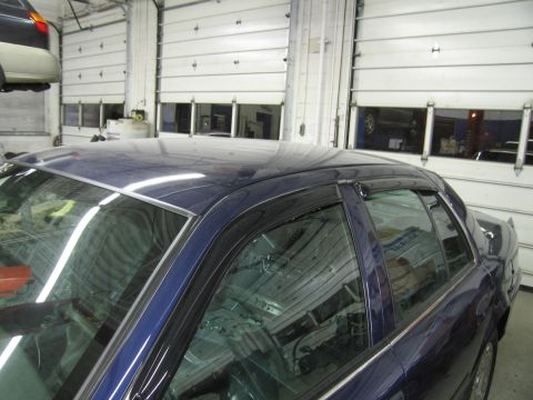 1991 Ford LTD Crown Victoria - Side profile of a 1991 Ford Crown Victoria LTD with dark blue paint and window visors.