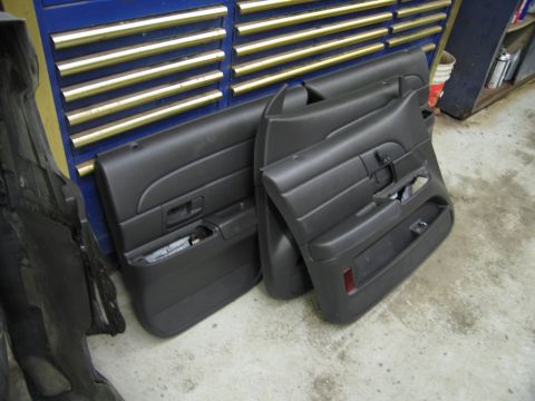 1991 Ford LTD Crown Victoria - Car door panels are shown leaning against a tool chest in a garage setting.