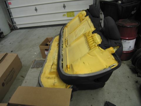 1991 Ford LTD Crown Victoria - Disassembled car seat components are visible, with yellow foam padding exposed and black fabric upholstery torn.