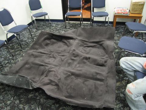 1991 Ford LTD Crown Victoria - A car floor mat is spread out on the floor of a room with chairs.