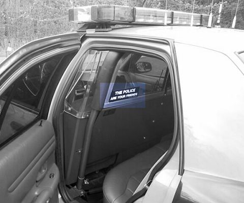 2001 Ford Crown Victoria - A sticker inside a police car reads 'The Police Are Your Friends'.