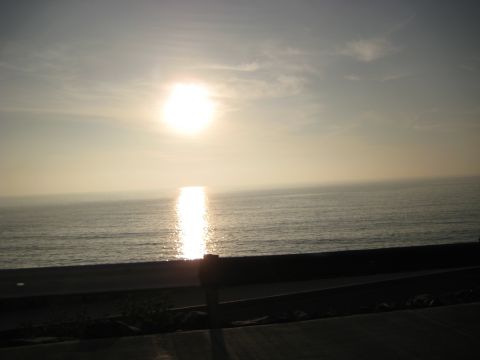 1996 Ford Bronco - The sun sets over the ocean, creating a bright reflection on the water's surface.