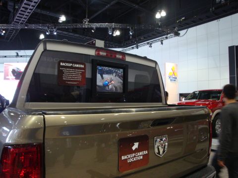 1993 Ford Taurus - Dodge Ram pickup truck rear view with backup camera display and a red vehicle in the background.