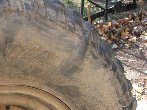 1996 Ford Bronco - Muddy tire with T/A markings visible on the sidewall.